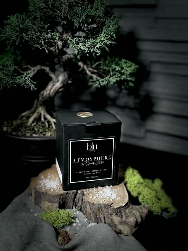 A lit Gravity artisan candle on a modern desk, providing a grounded home fragrance to help focus and quiet the chaos