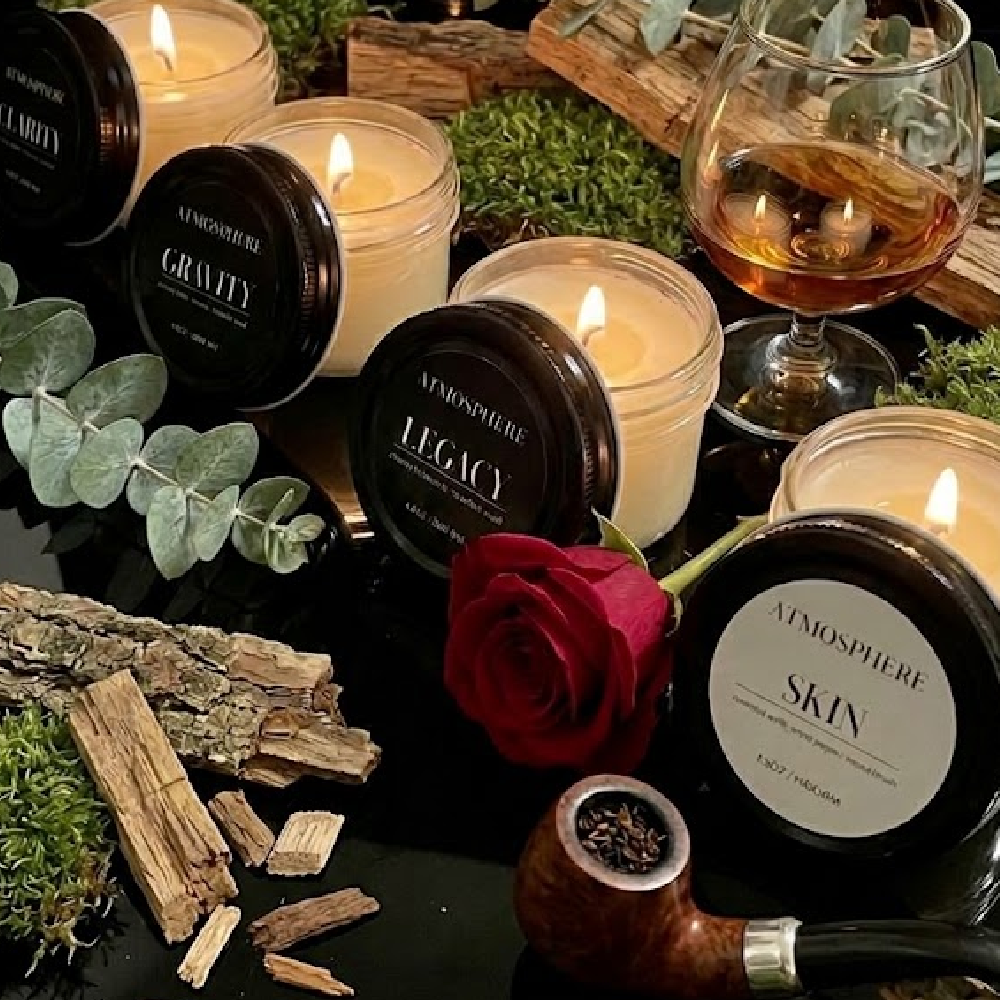 Four lit 3.5oz candles from The Icons Discovery Set glowing against dark background
