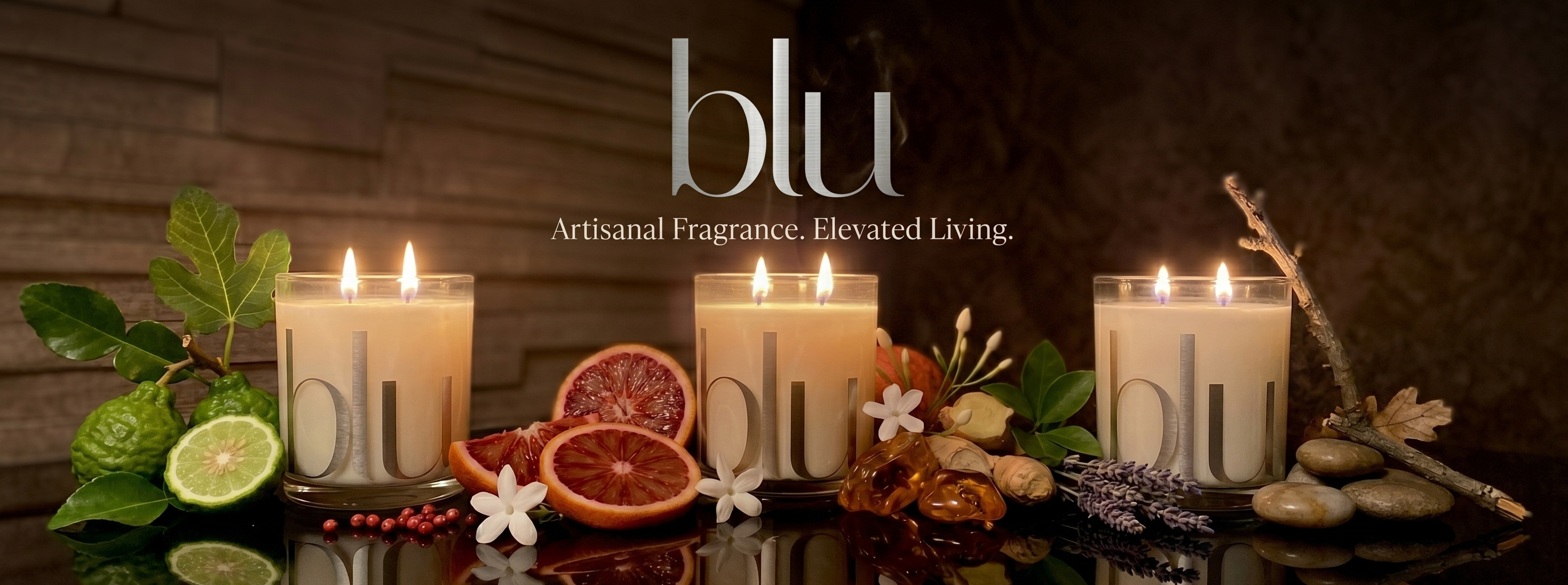 Candles with 'blu' branding on a reflective surface with decorative elements.