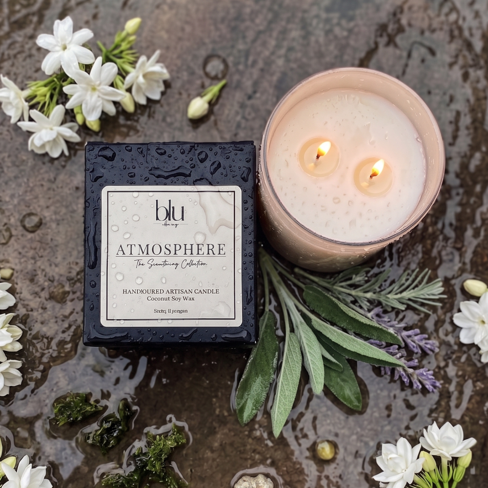 Blu Atmosphere candle with packaging and floral elements on a textured surface